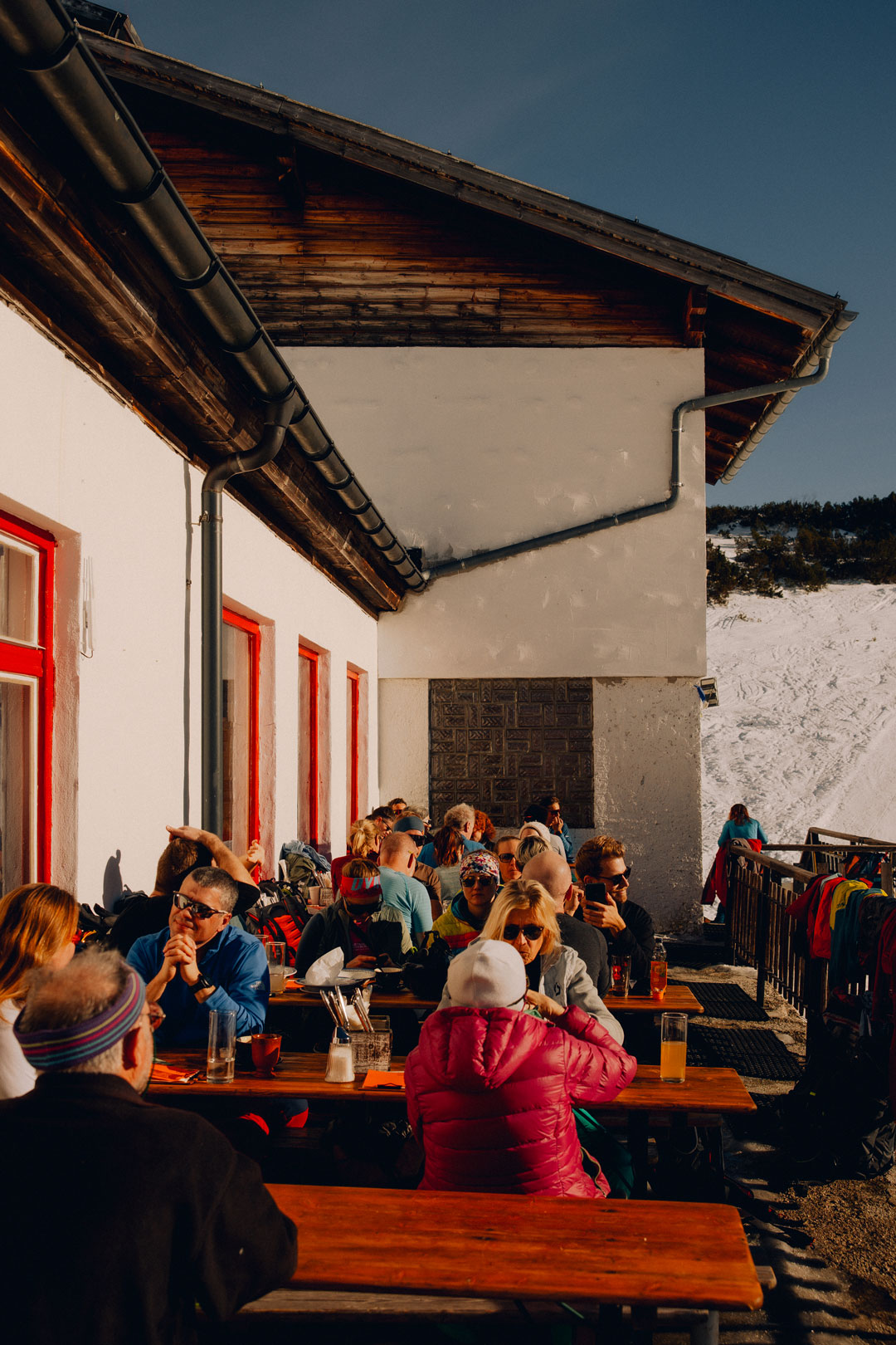 Volle Terrasse auf der Gjaid Alm im Winter bei Sonne